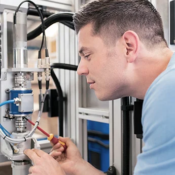 Person arbeitet an einer technischen Anlage